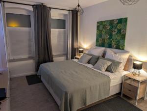 a bedroom with a large bed and two windows at Helles Studio mit Arbeitsplatz und Balkon in Chemnitz