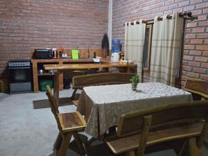 Habitación con mesa, sillas y pared de ladrillo. en Casa de Campo en Buena Vista, en Buena Vista