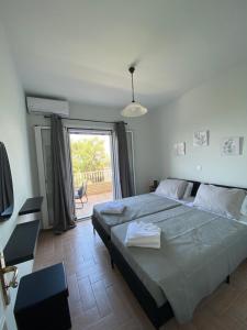 a bedroom with a large bed and a large window at Sea View House in Astrakeri