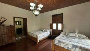 a bedroom with two beds and a chandelier at El Balcón de Emma in Jardin