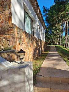 a stone building with a light on the side of a sidewalk at Kilua in Punta del Este