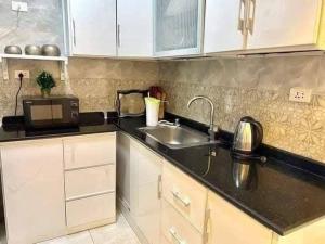 a kitchen with a sink and a microwave at القرية الذكيةبريتال فيو اكوا بارك in El Alamein