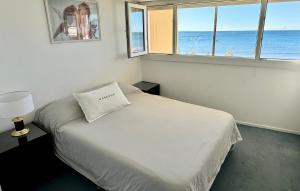 ein Schlafzimmer mit einem Bett und Meerblick in der Unterkunft Boulevard 10 - Dúplex frente al mar con balcón y vista panorámica in Puerto Madryn + 8 Fotos