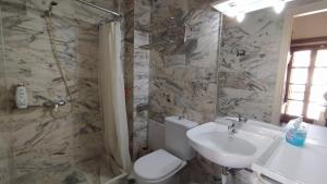 a bathroom with a sink and a toilet and a shower at Vaporia in Ermoupoli