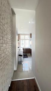 a white kitchen with a brick wall and a table at Exclusive Apartment in Grudziądz +33 photos