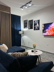a living room with a blue couch and a table at Apartman Carpe Diem in Ortijes +9 photos