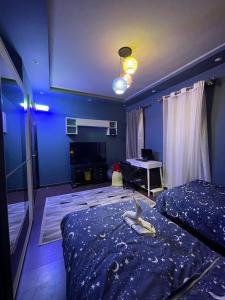 a blue room with a bed and a desk in it at Amazing 3br Villa in Emaar - Mivida in New cairo