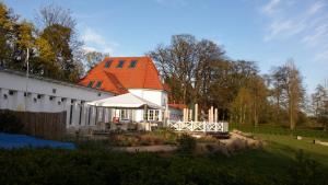 a large white building with an orange roof at Residenz Zum Kronprinzen in Bad Saarow