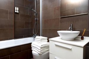 a bathroom with a sink and a toilet and a tub at Grand Central Market Suites By VALENCIAFLATS EU in Valencia +5 photos