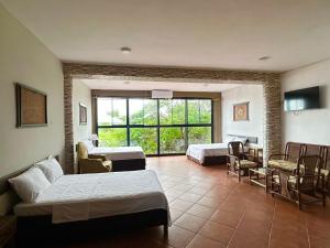 a hotel room with two beds and a window at La Posada del Cauchero Hotel & Suites in Iquitos