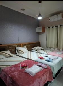 two beds in a hotel room with towels on them at Hotel rebeka in São Paulo
