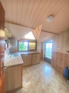 a large kitchen with wooden cabinets and a window at Espace vert Chalet familial à Azrou in Azrou
