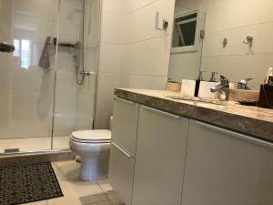 Un baño con inodoro, lavabo y ducha. en Altos da Bela Vista, en Gramado 13 fotos más