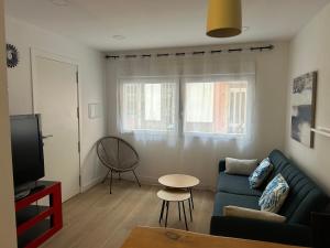 a living room with a blue couch and a tv at Del Carmen in Vinarós