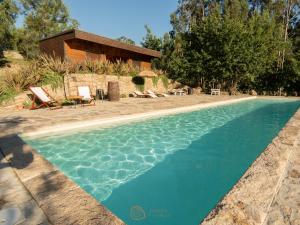 a swimming pool in front of a house at Tapada dos Vales in Arnoia
