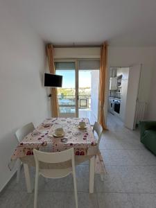 a dining room with a table and chairs and a kitchen at Nido dei gabbiani in Bisceglie