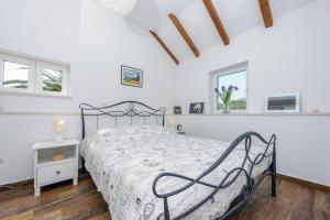 a bedroom with a bed and two windows at Apartment Island Oasis in Koločep