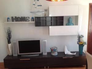 ein Wohnzimmer mit einem TV auf dem Tisch in der Unterkunft Casa do Mar in Sesimbra