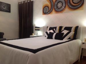 ein Schlafzimmer mit einem großen Bett mit schwarzen und weißen Kissen in der Unterkunft Casa do Mar in Sesimbra