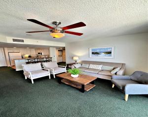 a living room with a couch and a ceiling fan at Wyndham Ocean Walk Resort - Vacation in Comfort by the sea - 2BR Oceanview 24320 in Daytona Beach