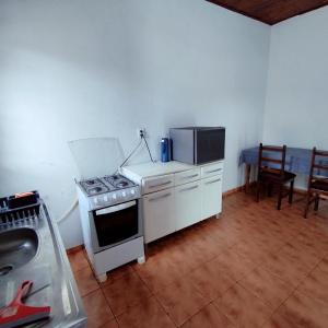 a kitchen with a stove and a microwave at Apartamento com Ar Condicionado in Nova Andradina