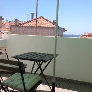 a picnic table and a chair on a balcony at Casa do Mar in Sesimbra