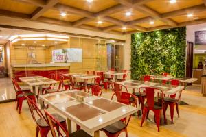 a restaurant with tables and chairs and a green wall at Hotel Rosita in Lucena