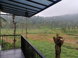 a room with a balcony with a view of a field at The Tree House in Vythiri +6 photos