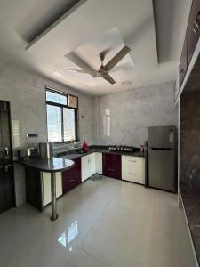 cocina grande con ventilador de techo y mesa en Fatima Villa, en Kolhapur