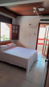 a bedroom with a white bed in a room at Hotel raizes in Conceição do Coité