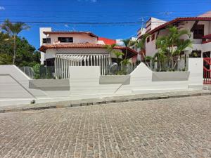 a street with a white fence and some buildings at Hotel raizes in Conceição do Coité