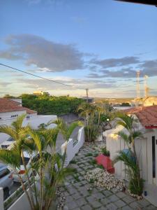 a view of a backyard with palm trees and buildings at Hotel raizes in Conceição do Coité