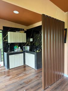 a kitchen with black counter tops and a wooden floor at Tesoro Quimbaya IG quimbayacabana in La Florida