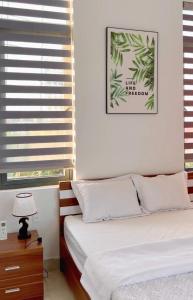 a bedroom with a bed with white sheets and a window at 150 Homestay in Dong Hoi