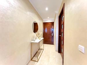 a hallway with a door and a table with vases on it at Golden Breeze in Cabo Negro