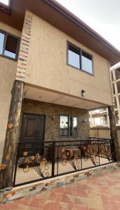 a house with a balcony with a fence at Trio Grove in Tema