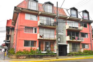 a red building on the corner of a street at Dpto central y acogedor in Valdivia +5 photos