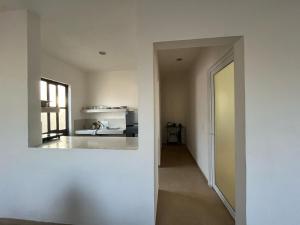 an empty room with a kitchen and a hallway at Casa Yaxche 1 in Izamal +3 photos