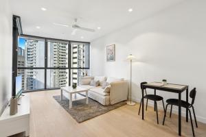 a living room with a couch and a table at Brisbane 1BR with Pool, Spa, Sauna and Balcony in Brisbane +18 photos