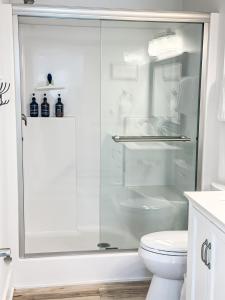 a white bathroom with a shower with a toilet at Redhead Cove-3bed2bathdockgrillfirepit-10pp in Osage Beach +27 photos