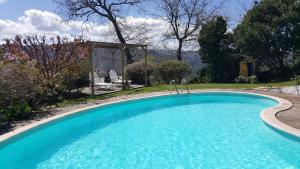 a large swimming pool in a yard with a house at Casa de Tapadeiro in Resende