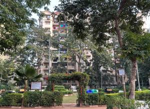 a large apartment building in front of a park at AC Luxury Appt 2BHK in Satellite Ahmedabad in Ahmedabad