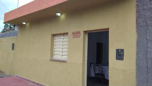 a yellow building with a window and a door at Depa norte in La Rioja