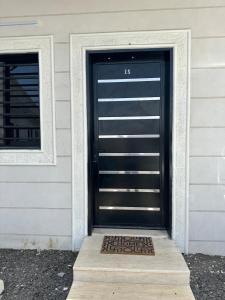 a black garage door with a welcome mat in front of it at Quite Studio in Abha