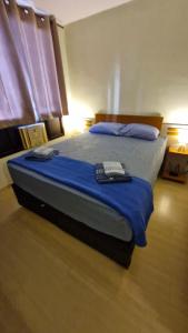 a bedroom with a bed with a remote control on it at Suíte Aconchegante em Copacabana - Piscina, Wi-fi e perto da praia in Rio de Janeiro