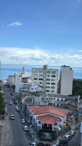 a city street with cars and buildings and the ocean at Apartamento inteiro 2 quartos Porto Barra Vista Mar in Salvador