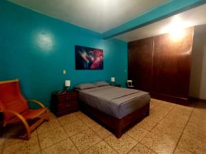 a blue bedroom with a bed and a chair at Habitación MAGIA, muy cómoda y céntrica en Mali in Malinalco