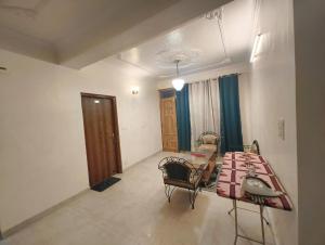 a room with a bed and a table and chairs at Fair lawns Home Stay in Shimla