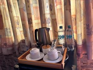 a tray with cups and saucers and bottles of water at Hotel Alicia in El Puente