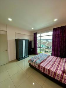 a bedroom with a bed and a large window at SK Holiday Apartment in Tanah Rata